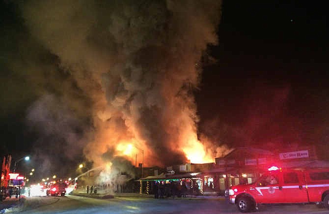 In this Tuesday, Dec. 30, 2014 photo provided by Kate Wiltshire, firefighters attack a raging fire in Dubois, Wyo. Huge flames ripped through historic buildings in the picturesque western Wyoming town as firefighters contended with sub-zero temperatures that froze their hoses and other equipment. Four buildings containing more than a dozen businesses were destroyed, but Mayor Twila Blakeman credited firefighters with keeping the flames from spreading even further. 