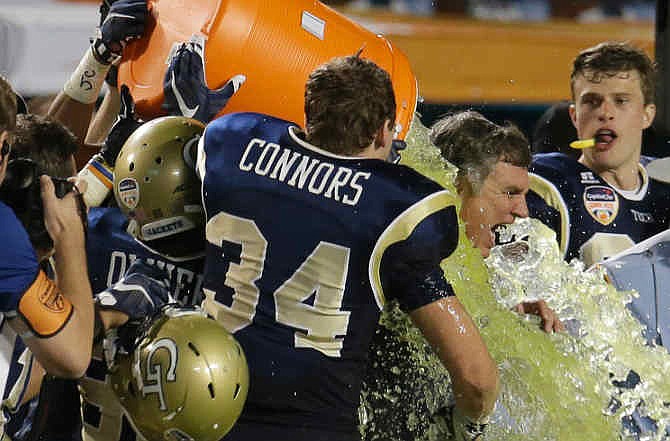 Georgia Tech head coach Paul Johnson, right, is drinched after Georgia Tech defeated Mississippi State 49-34 in the Orange Bowl NCAA college football game, Wednesday, Dec. 31, 2014, in Miami Gardens, Fla.