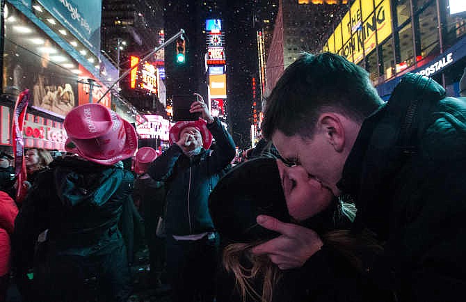 Sean Reilly and Emily Verselin share a kiss at midnight in Times Square during a New Year's Eve celebration, Thursday, Jan. 1, 2015, in New York. Thousands braved the cold to watch the annual ball drop and ring in the new year. 
