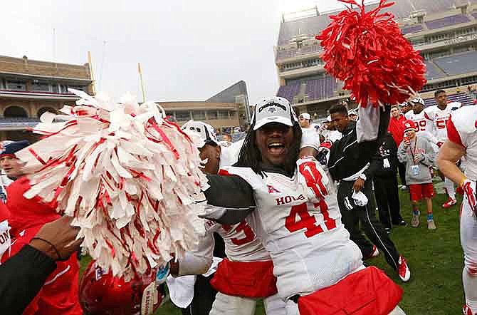 Houston linebacker Steven Taylor (41) celebrates while singing the school song and holding pom poms after they defeated Pittsburgh 35-34 in the Armed Forces Bowl NCAA college football game, Friday, Jan. 2, 2015, in Fort Worth, Texas. 