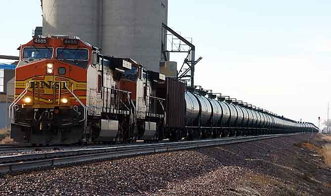 In this Nov. 6, 2013, file photo, a BNSF Railway train hauls crude oil near Wolf Point, Mont. A collapse in oil prices won't derail the railroads' profit engine even if it does slow the tremendous growth in crude oil shipments seen in recent years. Railroads went from hauling 9,500 carloads of crude oil in 2008 to 435,560 last year, as production boomed and oil routinely sold for $90 a barrel or more. But even with the surge, crude oil shipments remain less than 2 percent of all the carloads major U.S. railroads deliver.