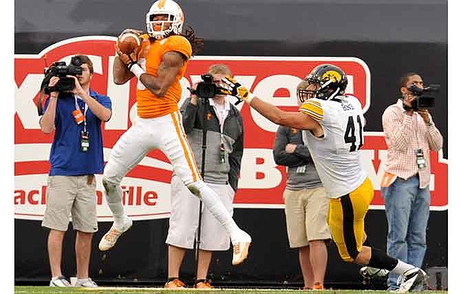 Tennessee's Von Pearson, left, pulls in a touchdown pass during the first half of the TaxSlayer Bowl NCAA college football game against Iowa, Friday, Jan. 2, 2015, in Jacksonville, Fla.