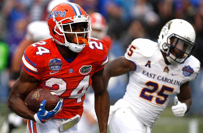 Florida defensive back Brian Poole (24) returns an interception for a touchdown during the first half of an Birmingham Bowl NCAA college football game against East Carolina Saturday, Jan. 3, 2015, in Birmingham, Ala.