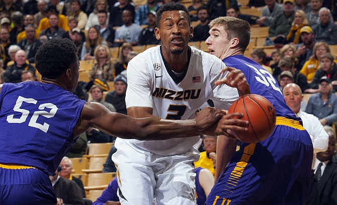 Missouri's Johnathan Williams III, center, is fouled by Lipscomb's Malcolm Smith, left, as he tries to squeeze by Brett Wishon, right, during the first half of an NCAA college basketball game Saturday, Jan. 3, 2015, in Columbia, Mo.