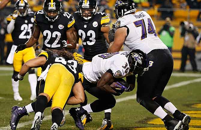 Baltimore Ravens running back Bernard Pierce (30) gets past Pittsburgh Steelers strong safety Troy Polamalu (43) for a touchdown in the second quarter of an NFL wildcard playoff football game against the Baltimore Ravens, Saturday, Jan. 3, 2015, in Pittsburgh.