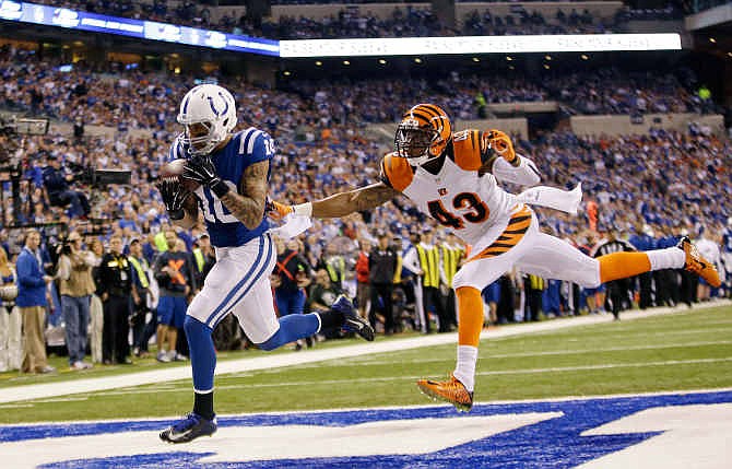 Indianapolis Colts wide receiver Donte Moncrief (10) makes a 36-yard touchdown reception against Cincinnati Bengals' George Iloka (43) during the second half of an NFL wildcard playoff football game Sunday, Jan. 4, 2015, in Indianapolis.