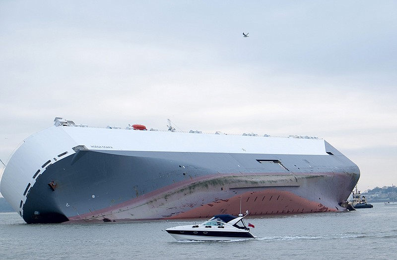 A small boat sails past the Hoegh Osaka car transporter cargo ship that ran aground in the Solent, off the Isle of Wight on Sunday.
