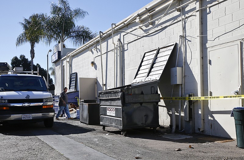 A plumber goes about his business Monday behind a pizza restaurant where a three-week-old infant, identified as Eliza Delacruz, was found dead Sunday in Imperial Beach, Calif. The baby's parents and uncle were all shot and wounded in Long Beach.