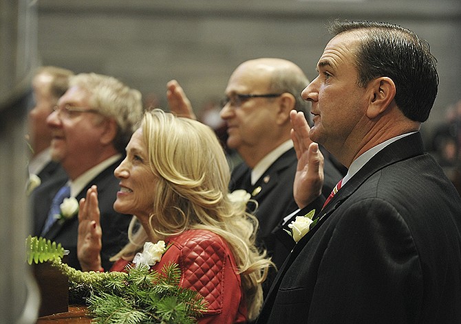 Sens. Mike Kehoe, right, R-Jefferson City, and Jeanie Riddle, R-Mokane, raise their hands as they repeat the oath of office during swearing-in ceremonies Wednesday.