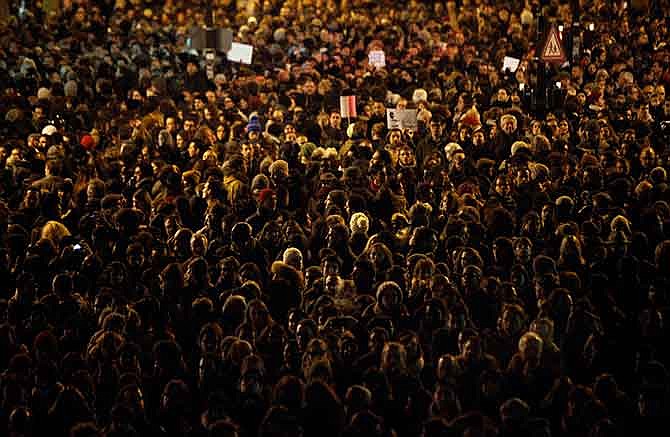 People gather to pay their respects for the victims of a terror attack against a satirical newspaper, in Paris, Wednesday, Jan. 7, 2015. Masked gunmen shouting "Allahu akbar!" stormed the Paris offices of a satirical newspaper Wednesday, killing 12 people, including the paper's editor, before escaping in a getaway car. It was France's deadliest terror attack in living memory. 