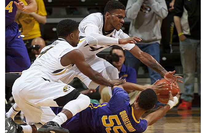 Missouri's Keith Shamburger, top, and Tramaine Isabell, left, dive onto LSU's Tim Quarterman, bottom, as he tries to pass the ball during the first half of an NCAA college basketball game Thursday, Jan. 8, 2015, in Columbia, Mo. 