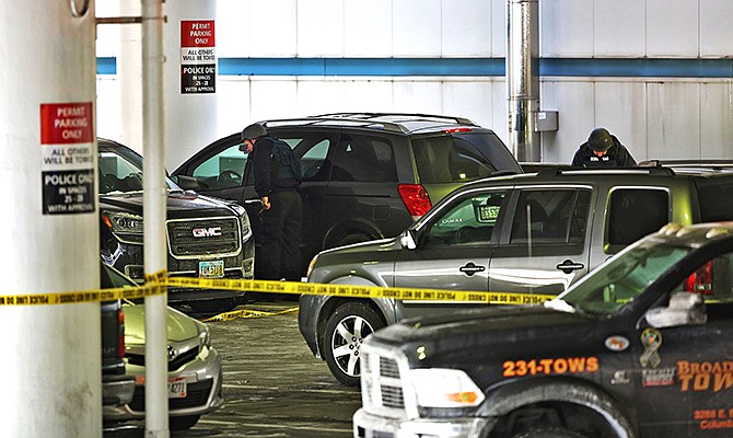 Members of the bomb squad check out a parked SUV at port Columbus Airport on Wednesday, after police shot a man in Columbus, Ohio. A man who tried to buy an airline ticket using a fake ID was fatally shot Wednesday after returning to his illegally parked car, where he lunged at an airport police officer with a knife during a confrontation, police said.  