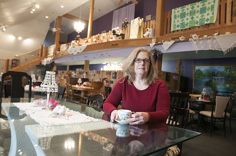 Cherie Rutter, owner of Cherie's Cake Boutique and Tea Room, poses for a photo with a tea cup inside her tea room on Thursday. Rutter said she dreamed of opening her own tea room for years and has enjoyed having her own business since July.