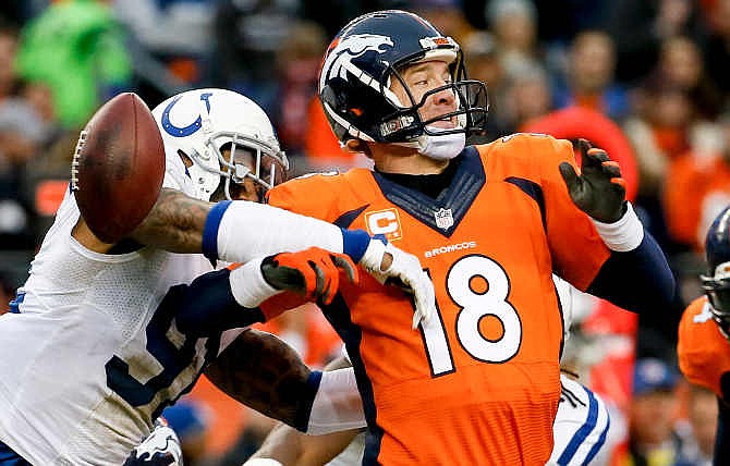 Indianapolis Colts linebacker Jonathan Newsome, left, reaches in to force Denver Broncos quarterback Peyton Manning fumble during the first half of an NFL divisional playoff football game, Sunday, Jan. 11, 2015, in Denver. 