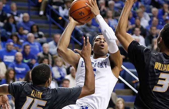 Kentucky's Andrew Harrison shoots between Missouri's Wes Clark (15) and Johnathan Williams, III (3) during the second half of an NCAA college basketball game in Lexington, Ky., Tuesday, Jan. 13, 2015. Kentucky won 86-37.