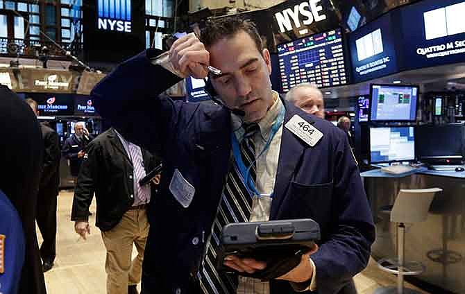 Trader Gregory Rowe wipes his forehead as he works on the floor of the New York Stock Exchange Wednesday, Jan. 14, 2015. Stocks are falling and bond prices are rising following some discouraging news on the U.S. economy and a weaker forecast of global growth.
