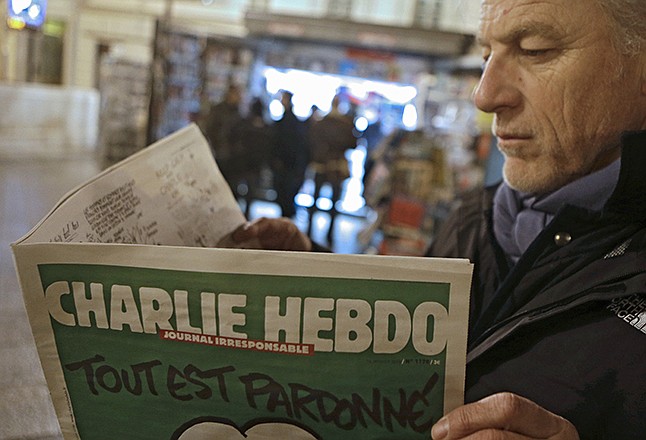 Jean Paul Bierlein reads the new Charlie Hebdo outside a newsstand in Nice, southeastern France, Wednesday. In an emotional act of defiance, Charlie Hebdo resurrected its irreverent and often provocative newspaper, featuring a caricature of the Prophet Muhammad on the cover that drew immediate criticism and threats of more violence.