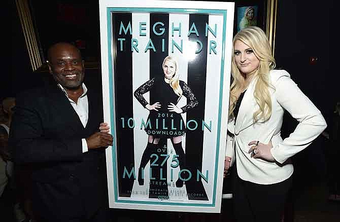 Chairman of Epic Records LA Reid, left, presents Meghan Trainor with her 10 million+ global sales plaque at her Epic Records album release party sponsored by Clinique at Warwick on Tuesday, January 13, 2015, in Hollywood, Calif. (Photo by John Shearer/Invision for Epic Records/AP Images)