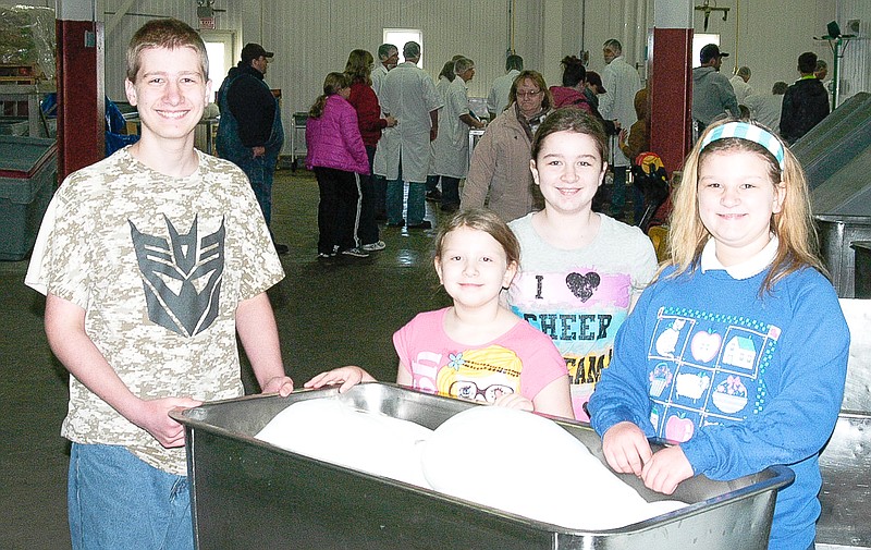 Members of the Happy Clover 4-H Club, Westphalia, set off with the hams they have selected and began the curing process on Saturday, Jan. 10. They are, from left, Isaac, Aubrey, Courtney and Lorelei Wieberg.