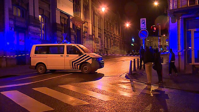 In this image made from video, members of the public stand behind police tape after security forces took part in anti-terrorist raids in Verviers, eastern Belgium. Belgian authorities say two people have been killed and one has been arrested during a shootout in an anti-terrorist operation in the eastern city of Verviers.