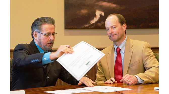 J. R. Flores, Missouri State Conservationist for the Natural Resources Conservation Service of the USDA (left) and Bob Ziehmer, Director of MDC sign contracts that will provide more than $1 million in federal funds to the state agency for habitat conservation by Missouri private landowners.