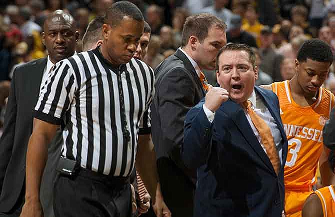 Tennessee coach Donnie Tyndall, right, argues a call with a referee during a timeout in the second half of an NCAA college basketball game against Missouri on Saturday, Jan. 17, 2015, in Columbia, Mo. Tennessee won 59-51.