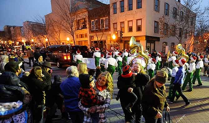 Attendees young and old alike enjoy the show from the corner of High and Madison Streets as the Blair Oaks marching band passes by during the 75th annual Jefferson City Jaycees Christmas Parade in December 2014.