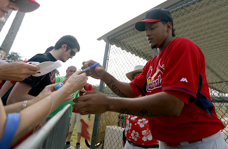 Cardinals pitcher Carlos Martinez signs autographs for fans following a spring training practice session last year in Jupiter, Fla.