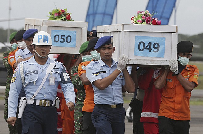 Members of the National Search and Rescue Agency carry coffins containing bodies of the victims aboard AirAsia Flight 8501 Monday, to transfer to Surabaya at the airport in Pangkalan Bun.