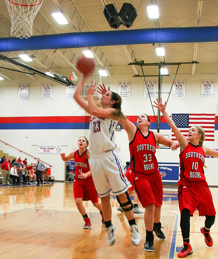 Lady Pintos senior guard Kamryn Koetting (23) gets past two Southern Boone defenders for an open shot in Friday night's consolation final at the California Basketball Tournament. Koetting had 12 points in her team's 60-46 loss.