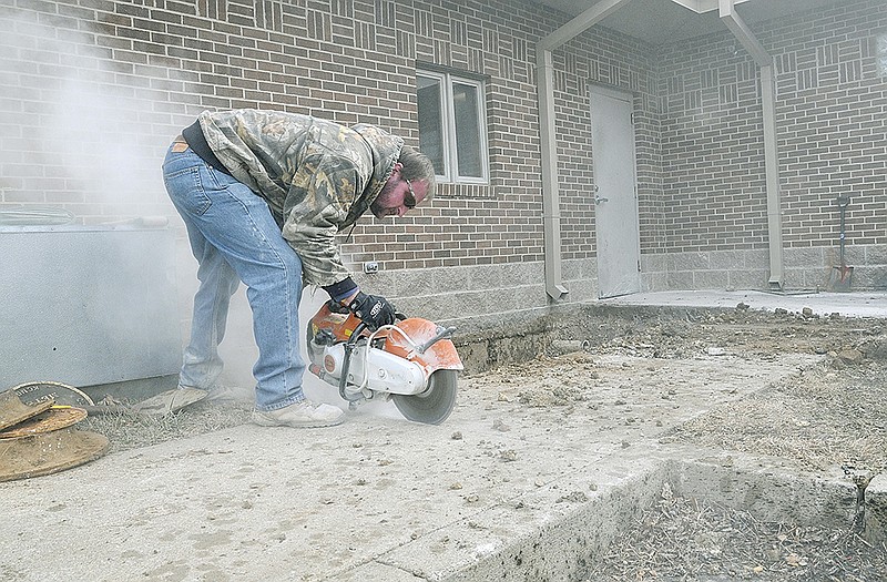 John Bilyeu cuts a section of sidewalk on the kitchen side of the Salvation Army Center of Hope. He is cutting to make way for a larger grease trap for the commercial kitchen. On the inside, co-workers cut sections of concrete to replace the existing two-inch water pipe with three-inch pipe. The kitchen will also replace their three-sink dishwashing station with a new automated dishwasher. 