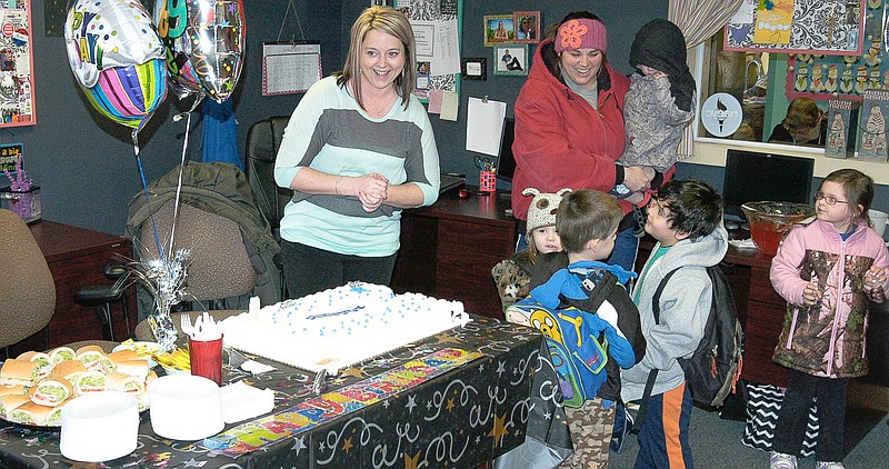 California-based Community Services Specialist Stefani Thompson prepares to serve cake to children and other guests to celebrate 50 years of CMCA community services.