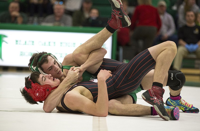 London Gaydos of Blair Oaks holds down Thomas Henderson from St. James during a dual Thursday night in Wardsville.