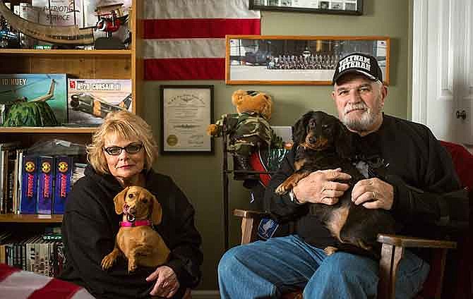
Vietnam veteran Bob Sneller and his wife Sandy sit with their dogs Roxie, left, and Riley, in their Holts Summit home. The Snellers faced foreclosure until a wave of support came in the form of local donations, helping them meet their financial needs and keep their house.