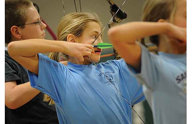 Reagen Kliethermes, center, a fifth grader at St. Joseph Catholic School in Westphalia, Mo., takes aim from the 15-yard line as she competes in the St. Martins Invitational archery tournament at St. Martins Catholic School on Saturday.