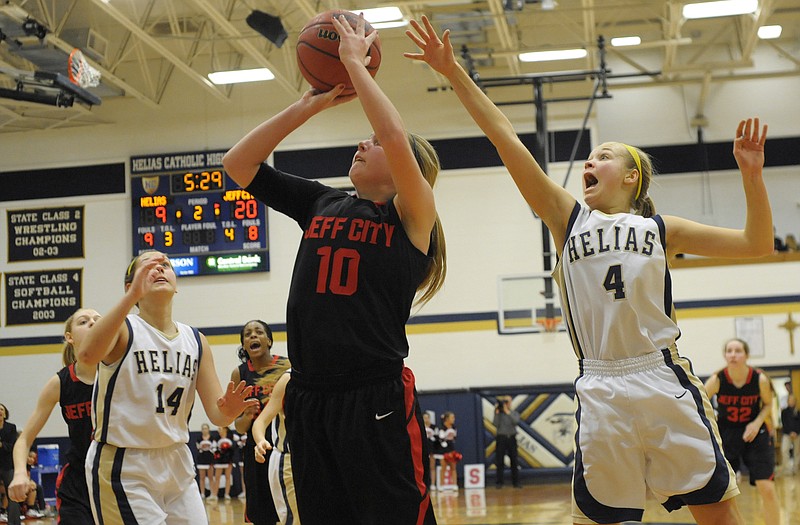 Jefferson City's Tayler LePage goes up for a layup as Helias' Luci Francka (4) and Ashley Rehagen defend during Monday night's game at Rackers Fieldhouse.