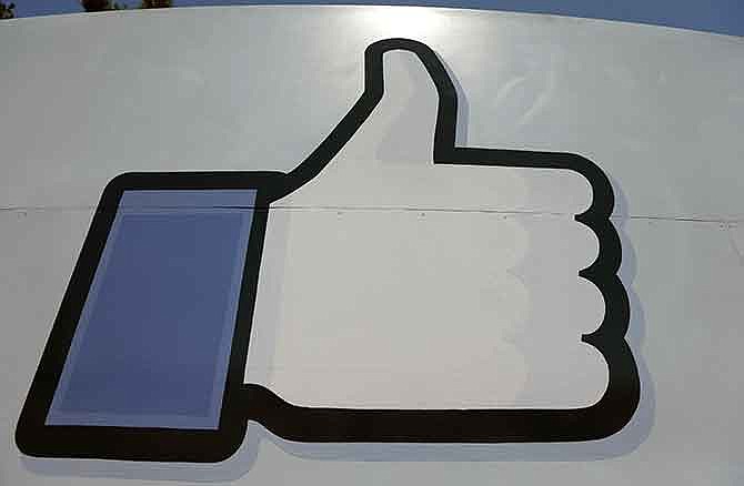 This June 11, 2014 photo shows Facebook's "like" symbol at the entrance to the company's campus in Menlo Park, Calif. 
