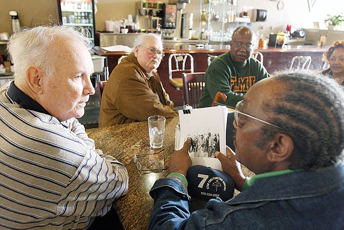 In this 2009 photo, Elwin Wilson, left, and Friendship 9 member Willie McCleod, right, look over pictures from civil rights incidents in Rock Hill, South Carolina in the 1960s. The criminal record will soon be erased for the nine black men arrested for integrating a whites-only South Carolina lunch counter 54 years ago. 