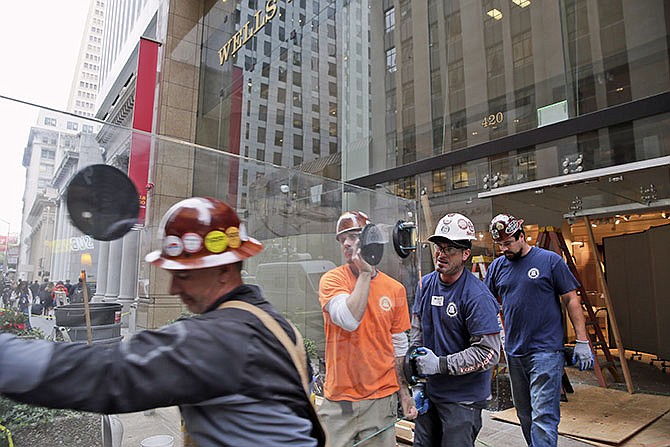 Workers remove a damaged pane of glass at the Wells Fargo History Museum in San Francisco on Tuesday. Thieves in a sport utility vehicle smashed through the glass doors of the museum in downtown San Francisco and made off with gold nuggets on display. 