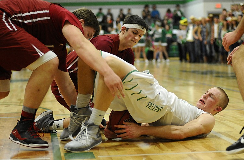 Owen Luebbering of Blair Oaks tries to fight off Linn's Daulton Niederhelm (left) and Alec Strope after diving for a loose ball in the first half of Friday night's game in Wardsville.