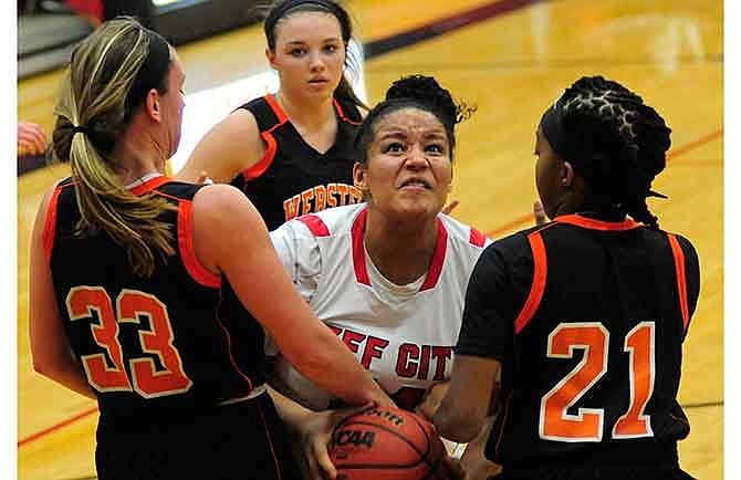 Jefferson City's Alexis Roberson tries to fight through the Webster Groves defense of (from left) Mal Moran, Rachael Sondag and Jaidah Stewart during Saturday's game at Fleming Fieldhouse.