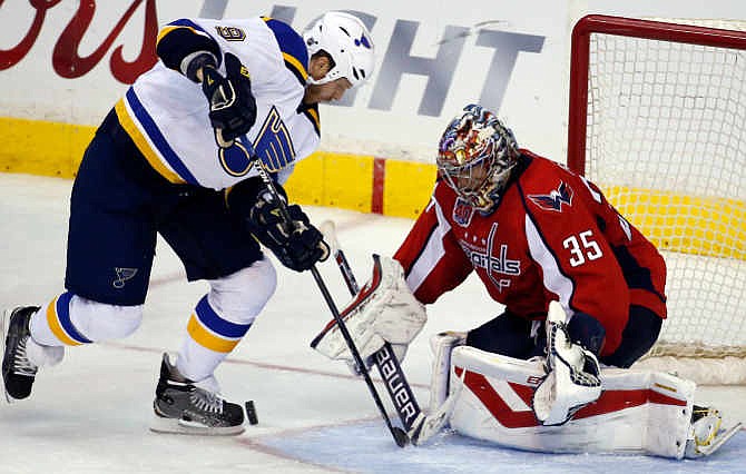 St. Louis Blues center Steve Ott (9) tries to work the bouncing puck in front of Washington Capitals goalie Justin Peters (35) in the third period of an NHL hockey game, Sunday, Feb. 1, 2015, in Washington. The Blues won 4-3. 