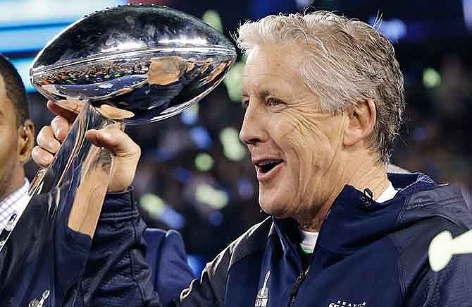 In this Feb. 2, 2014, file photo, Seattle Seahawks coach Pete Carroll holds the the Vince Lombardi Trophy after the Seahawks defeated the Denver Broncos 43-8 in Super Bowl XLVIII in East Rutherford, N.J. Carroll's Seahawks will face Bill Belichick's New England Patriots Sunday evening in the Super Bowl with a chance to do something that, for many reasons, was thought to be too tall a task in today's NFL: win a second consecutive championship.