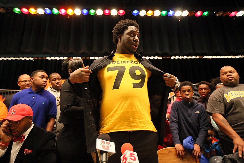 East St. Louis (Ill.) High School defensive lineman Terry Beckner Jr. unveils a Missouri T-shirt underneath his dress shirt after announcing his intention Wednesday to to play for the Tigers in East St. Louis, Ill.