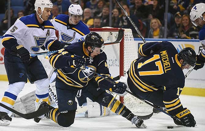 St. Louis Blues defenseman Barret Jackman (5) and left winger Alexander Steen (20) defend as Buffalo Sabres left winger Nicolas Deslauriers (44) and center Torrey Mitchell (17) battle for the puck during the first period of an NHL hockey game Saturday, Feb. 5, 2015, in Buffalo, N.Y. 