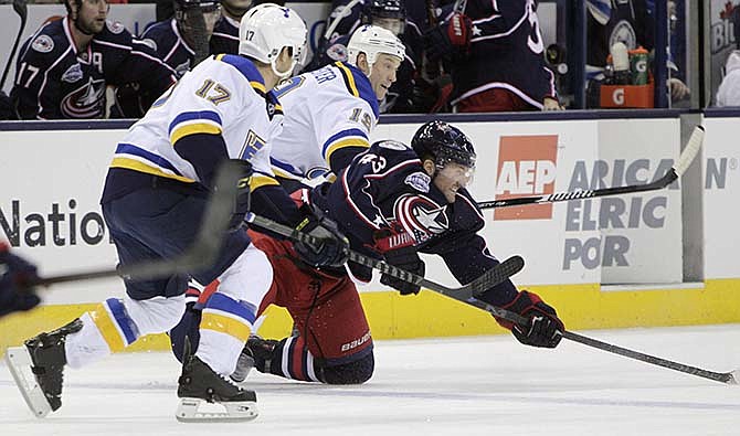 Columbus Blue Jackets' Scott Hartnell, right, clears the puck between St. Louis Blues' Jaden Schwartz, left, and Jay Bouwmeester during the first period of an NHL hockey game Friday, Feb. 6, 2015, in Columbus, Ohio.