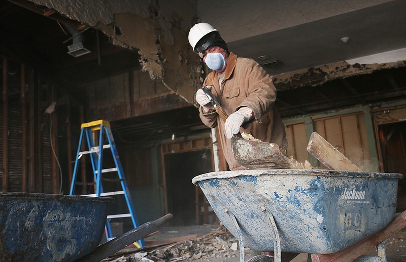 Chuck King with Glove Con General Contractors scoops up pieces of the wall his team demolished inside the old Fulton Theater on Court Street Monday afternoon.