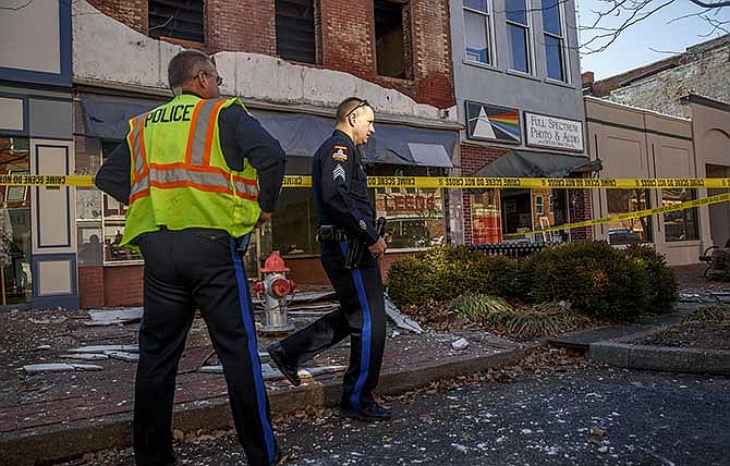 Jefferson City police examine the scene after the plaster facade on the upper stories of the Leed's building collapsed Saturday afternoon on High Street. One woman received a small cut, but no serious injuries were reported.