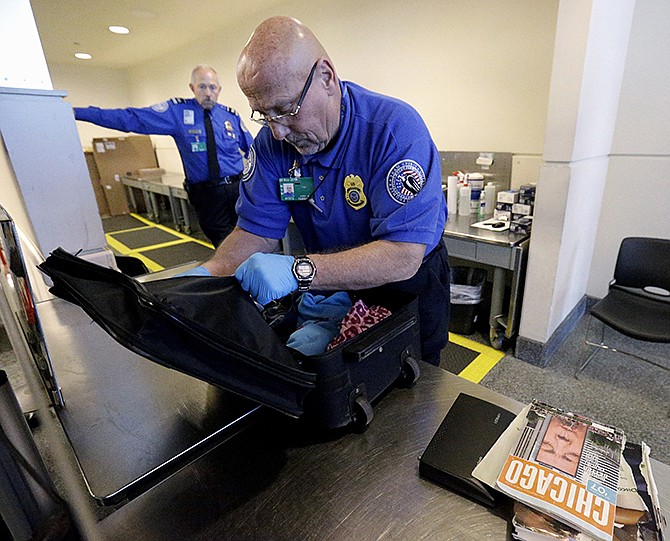 A TSA agent checks a bag at a security checkpoint area at Midway International Airport in Chicago in 2014. Spending for the Homeland Security Department hangs in the balance as Congress fights over unrelated immigration provisions attached by Republicans to the agency's annual spending bill. In the view of some House conservatives, though, shutting off the agency's budget is "not the end of the world." What would happen if Congress fails to reach a deal to renew homeland security spending by Feb. 27? 