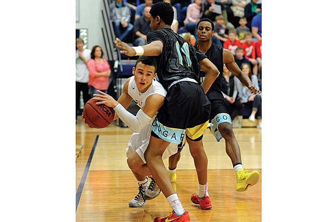 Helias point guard Isiah Sykes looks for an open Crusader teammate after drawing in the St. Louis Christian Academy defense Saturday night at Rackers Fieldhouse in Jefferson City.